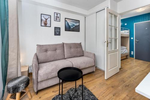 un salon avec un canapé et une table dans l'établissement Résidence Les Terrasses Du Soleil D'or - Chaleureux appartement aux portes des pistes MAE-6544, aux Orres