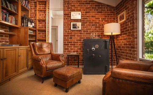 a living room with two chairs and a brick wall at The Reserve Barossa in Nuriootpa