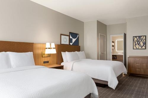 a hotel room with two beds and a bathroom at Staybridge Suites San Antonio Lackland AFB Area by IHG in San Antonio