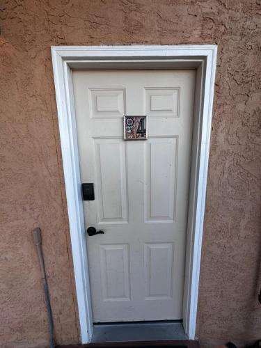 a white door with a sign on it at Adobe Rose Boutique Inn in Artesia