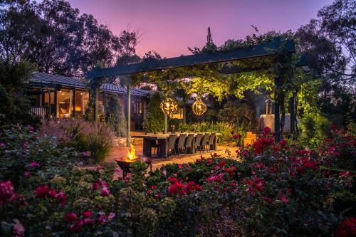 a garden with a pergola and a table and chairs at The Reserve Barossa in Nuriootpa