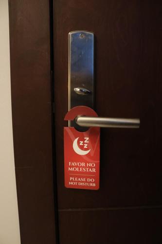 a door with a sign that says korea no mochi mats just for at Hotel Wellintown in Tijuana