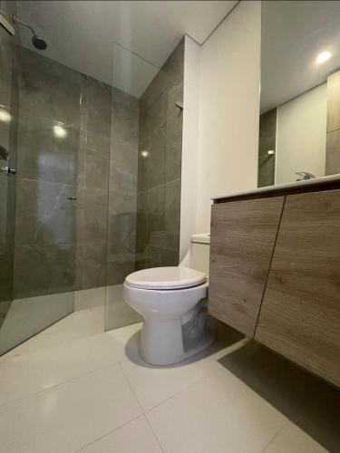 a bathroom with a toilet and a glass shower at Loft centro internacional in Bogotá