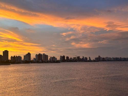 a sunset over a city with a large body of water at Pousada Refugio Paradisíaco 1 in Piçarras
