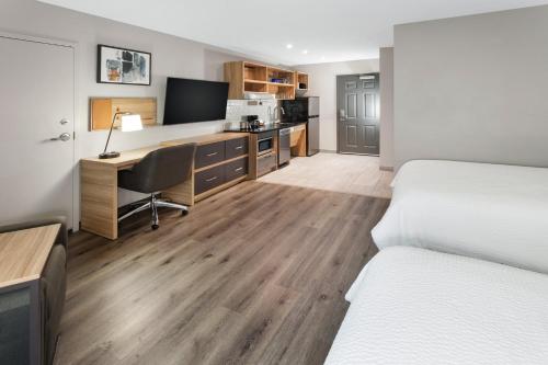 a hotel room with two beds and a desk with a computer at Candlewood Suites Harrisonburg by IHG in Harrisonburg