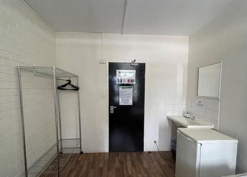 a black door in a room with a sink at Youth Shack Backpackers Darwin in Darwin