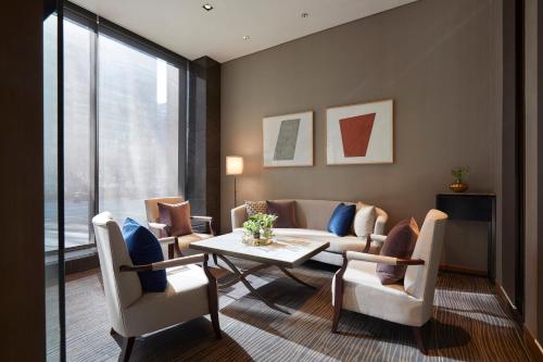 a living room with a couch and a table and chairs at Grand InterContinental Seoul Parnas by IHG in Seoul
