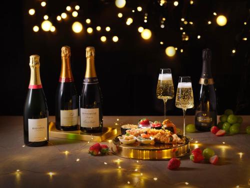 a table with three bottles of wine and a plate of food at Grand InterContinental Seoul Parnas by IHG in Seoul