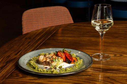 a plate of food on a table with a glass of wine at Hotel Indigo Denver Downtown - Union Station by IHG in Denver