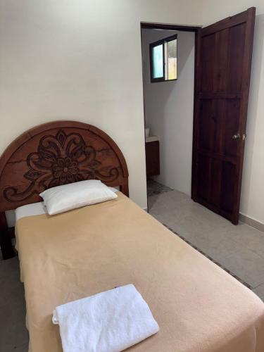 a bedroom with a large bed with a wooden headboard at My Family In Merida Hostel in Mérida