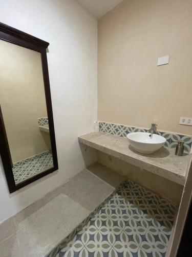 a bathroom with a sink and a mirror at My Family In Merida Hostel in Mérida