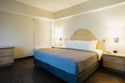 a hotel room with a large bed and a dresser at Hotel Parque Central in Monterrey