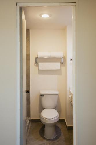 a bathroom with a white toilet and towels at Hotel Parque Central in Monterrey