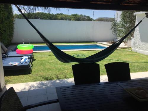a hammock on a patio next to a swimming pool at Casa con Alberca para 12 personas en Club de Golf el Cristo in Atlixco