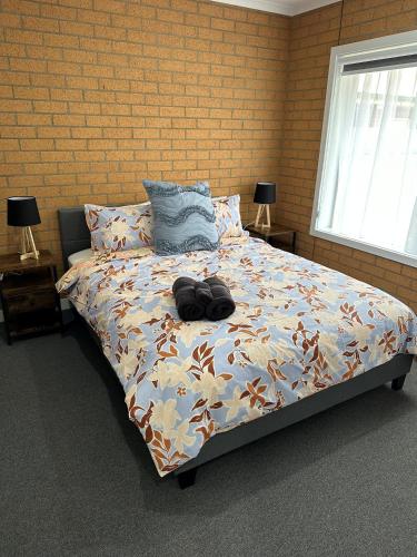 a bedroom with a bed with a bag on it at Lbarza Modern 1BR Apartment close to CBD in Shepparton