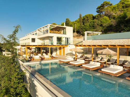 a resort with a swimming pool with chairs and a building at Myzith Luxury Suites in Keri
