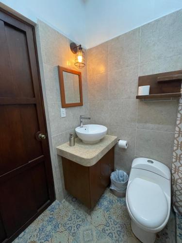 a bathroom with a toilet and a sink at My Family In Merida Hostel in Mérida
