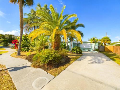 a palm tree on the side of a sidewalk at The Seaside Launch Pad in Cape Canaveral - NEW! in Cape Canaveral