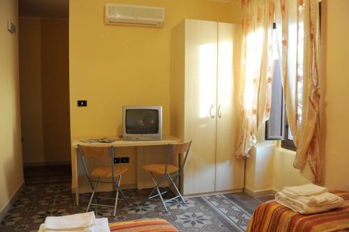 Habitación con escritorio, ordenador y TV. en L'Antica Dimora, en San Pietro Vernotico