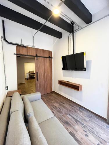 a living room with a couch and a flat screen tv at Eonia in Atlixco