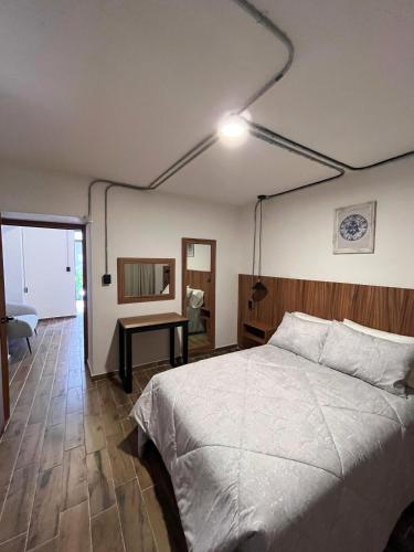 a bedroom with a large bed and a desk at Eonia in Atlixco