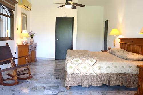 a bedroom with a bed and a ceiling fan at Casa de los Abuelos con Jardín y vista al Canal in Nuevo Vallarta 