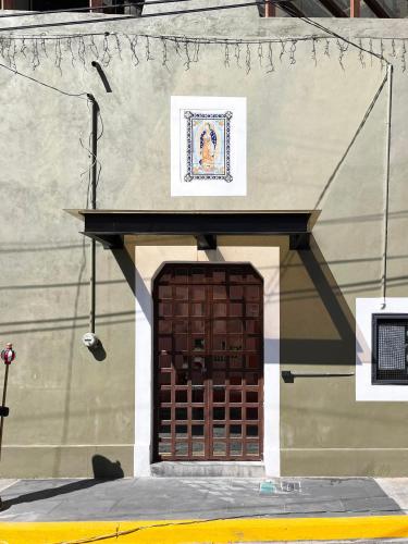 a building with a brown door with a sign above it at Eonia in Atlixco