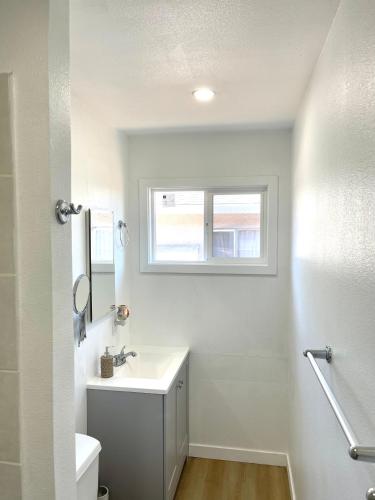 a white bathroom with a sink and a window at Cozy home Bay Area ROOM 2 in San Jose