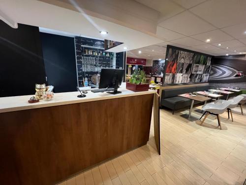 a lobby with a bar with chairs and a tv at Kyriad Rouen Sud - Oissel in Saint-Étienne-du-Rouvray