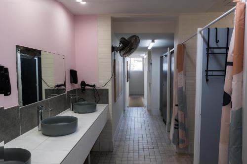 a bathroom with two sinks and a mirror at Youth Shack Backpackers Darwin in Darwin