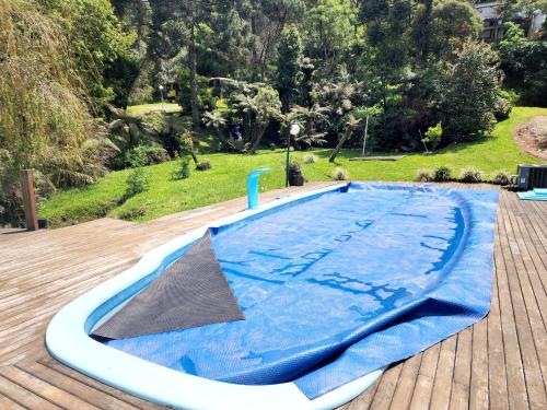 a large swimming pool with a blue cover on a deck at Casa de Campo em Gramado in Gramado