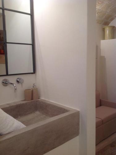 a bathroom with a bath tub with a mirror at L' Edera in Fasano