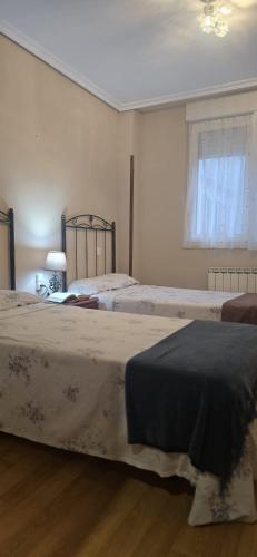 a bedroom with two beds and a window at Apartamento Céntrico UNQUERA Grupo RH - 16 in Unquera