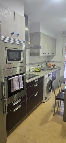 a kitchen with a stove and a microwave at Apartamento Céntrico UNQUERA Grupo RH - 16 in Unquera