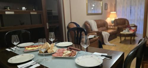 a table with plates of food and wine glasses at Apartamento Céntrico UNQUERA Grupo RH - 16 in Unquera