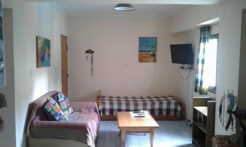 un salon avec un canapé et une table dans l'établissement Departamento Centro Villa Carlos Paz, à Villa Carlos Paz
