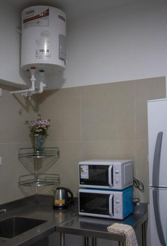 a microwave sitting on top of a kitchen counter at Sin Fin Hostel in Mendoza