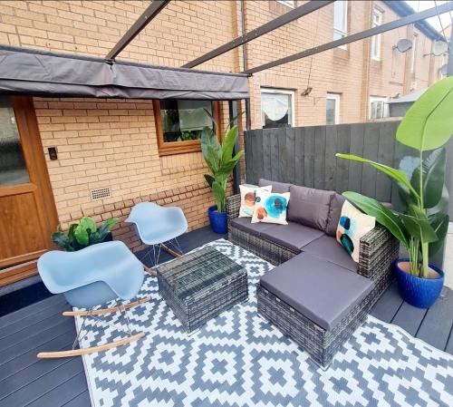 a patio with a couch and chairs on a deck at Bright 3BR walking distance to town - FREE parking in Glasgow