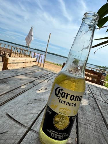 a bottle of corona beer sitting on a wooden table at Hermosa casa en Country Rincon Ituzaingo in Ituzaingó