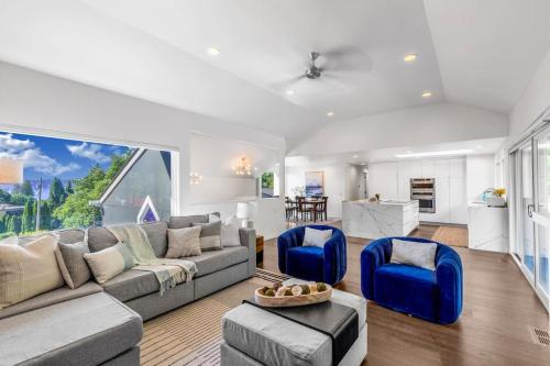a living room with a gray couch and blue chairs at Modern and Relaxing Lake Sammamish View House in Issaquah