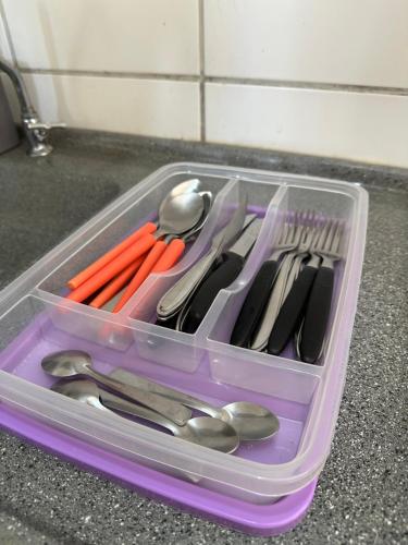 um recipiente de plástico cheio de utensílios num balcão em Aconchegante apt em Joao Pessoa em João Pessoa