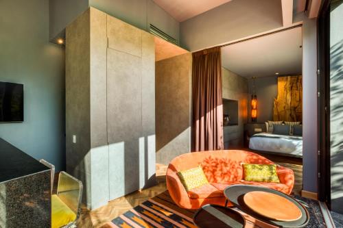 a living room with an orange couch and a bed at El Alfonsa in Mexico City