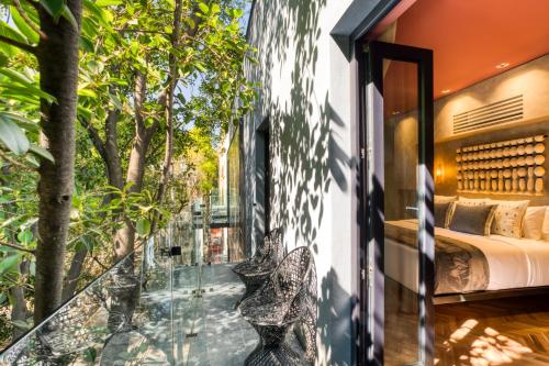 a glass balcony with a bed and trees at El Alfonsa in Mexico City