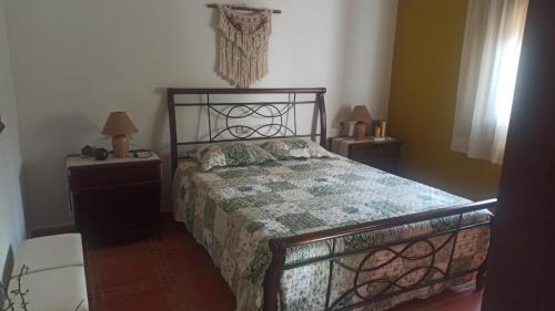 a bedroom with a bed and two tables and two lamps at Villa Castellanos in Tomelloso