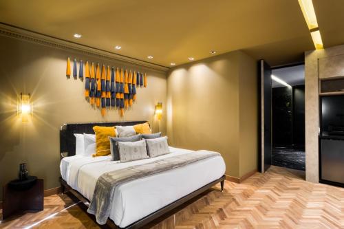 a bedroom with a large white bed with yellow pillows at El Alfonsa in Mexico City