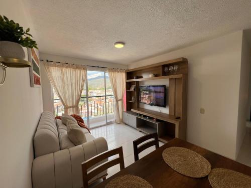 a living room with a couch and a tv and a table at Piso 11 con vista a la montaña, Callejuelas in Piedecuesta