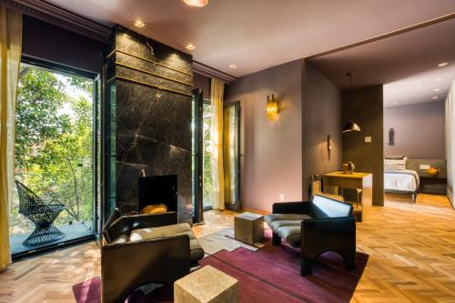 a living room with a fireplace and a bedroom at El Alfonsa in Mexico City