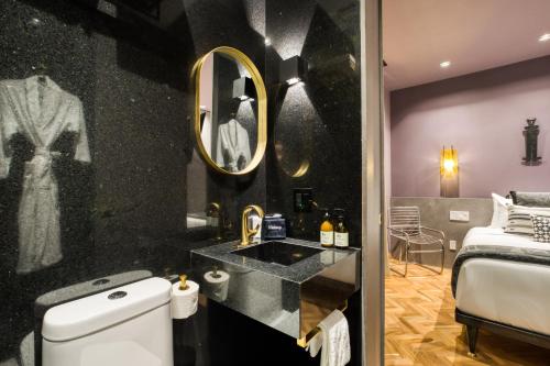 a bathroom with a sink and a bed and a mirror at El Alfonsa in Mexico City