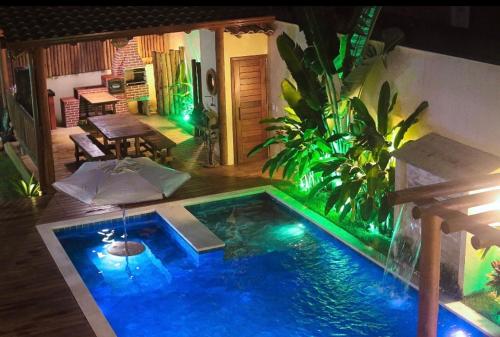 a small swimming pool with lights in a backyard at Village da Mata Arraial in Porto Seguro