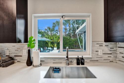 eine Küche mit einem Waschbecken und ein Fenster mit Aussicht in der Unterkunft Coconut Clubhouse - Heated Pool - Hot tub - Ping Pong in Fort Lauderdale